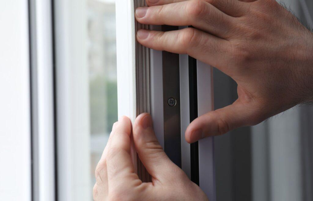 Person trying to stop draughts in their uPVC window