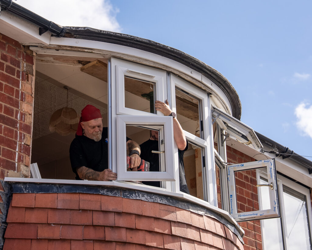 Window fitters installing uPVC bay window
