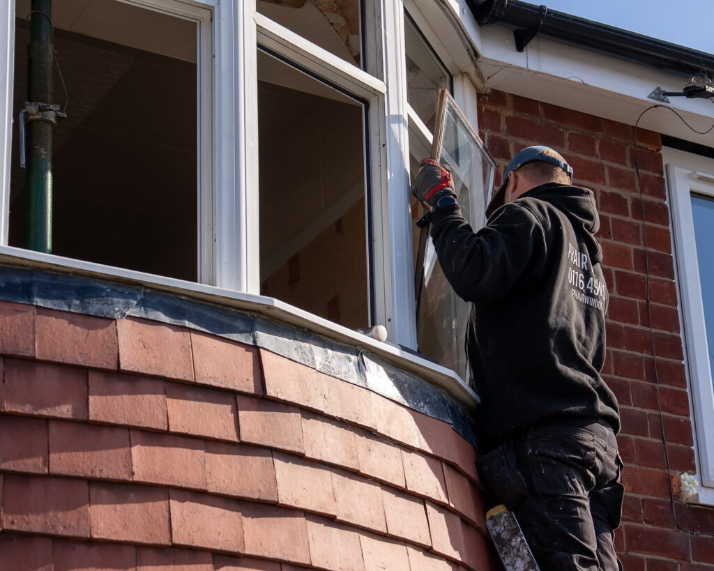 Window fitter installing glass in a window frame in Leicester property (1)