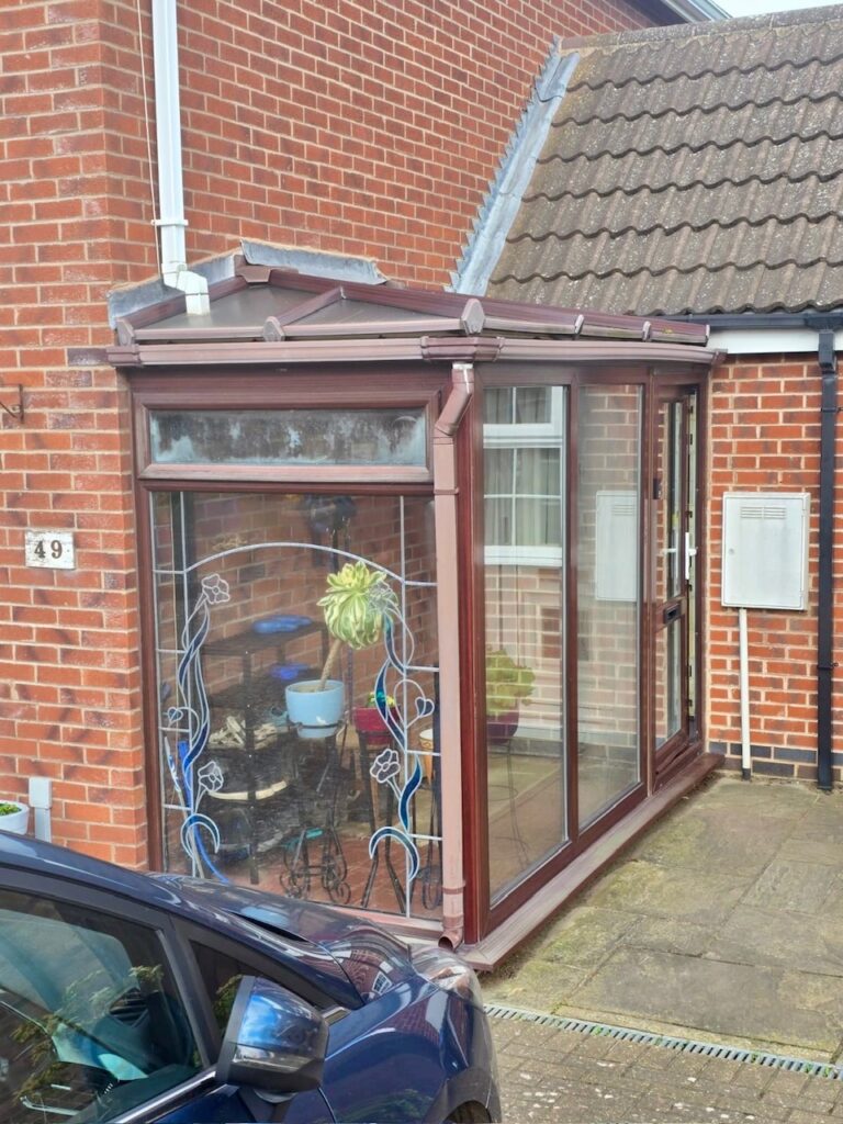 Existing rosewood uPVC porch with pitched roof in Bushby