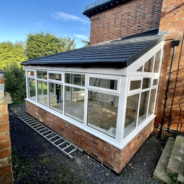 Modern lean to conservatory installed with white uPVC windows, French doors and tiled roof replacement