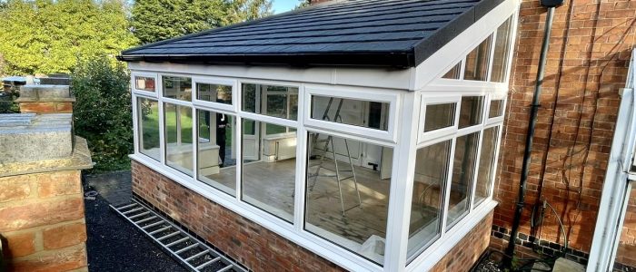 Modern lean to conservatory installed with white uPVC windows, French doors and tiled roof replacement