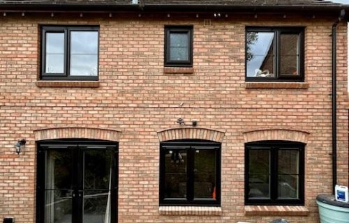 Full house of replacement uPVC black windows with new window cut out and brick archway to match Full house of replacement uPVC black windows with new window cut out and brick archway to match